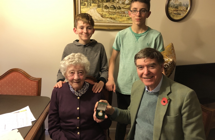 Philip Dunne MP presenting the Women’s Land Army badge to June Lee with her foster grandchildren Zac and Marcus Clements