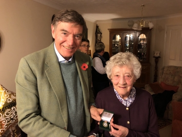 Philip Dunne MP presenting the Women’s Land Army badge to June Lee